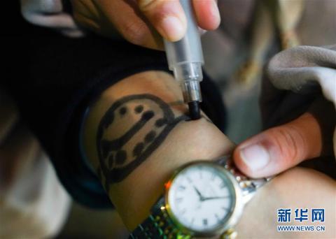 朵朵在站台上將母親手腕上稍有模糊的“手錶”描繪清晰。新華社記者胡晨歡攝
