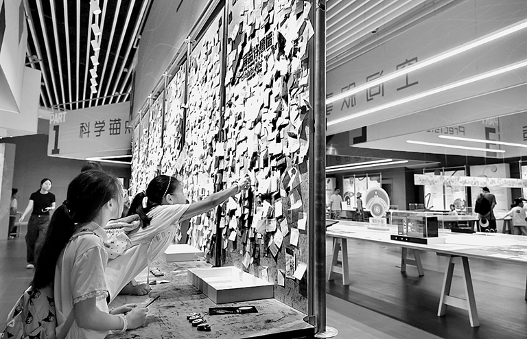 青少年在上海科技館&ldquo;從零到無窮 科技館展品誕生記&rdquo;展廳內設置的展品許願墻前張貼自己寫下的願望。新華社發