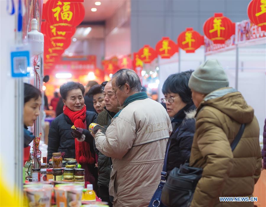 Residents select goods at a shopping fair held to greet the upcoming Spring Festival at Wuhan International Conference & Exhibition Center in Wuhan, capital of central China