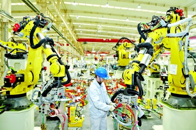 東風設備製造有限公司焊裝車間裏，工作人員正在調試混流産線。全正攝/光明圖片