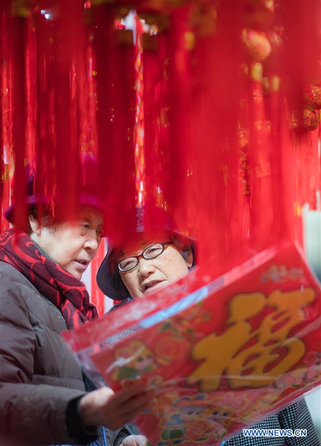 Residents select goods at a shopping fair held to greet the upcoming Spring Festival at Wuhan International Conference & Exhibition Center in Wuhan, capital of central China