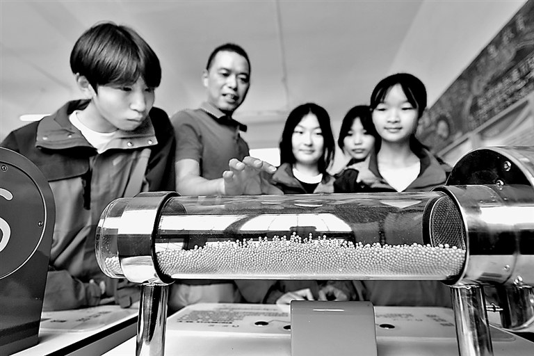在湖北省襄陽市保康縣過渡灣鎮中心學校&ldquo;流動科技館&rdquo;，教師指導學生體驗科技展品&ldquo;聲駐波&rdquo;。楊韜攝/光明圖片